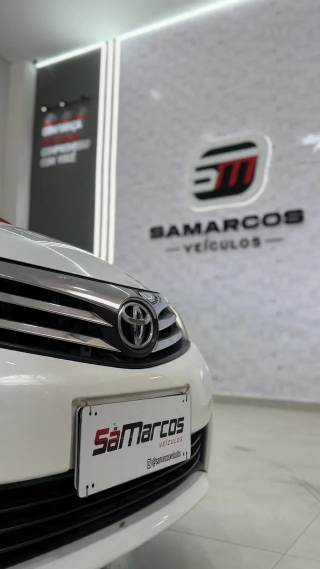 Toyota Corolla branco com placa decorativa da Sá Marcos
