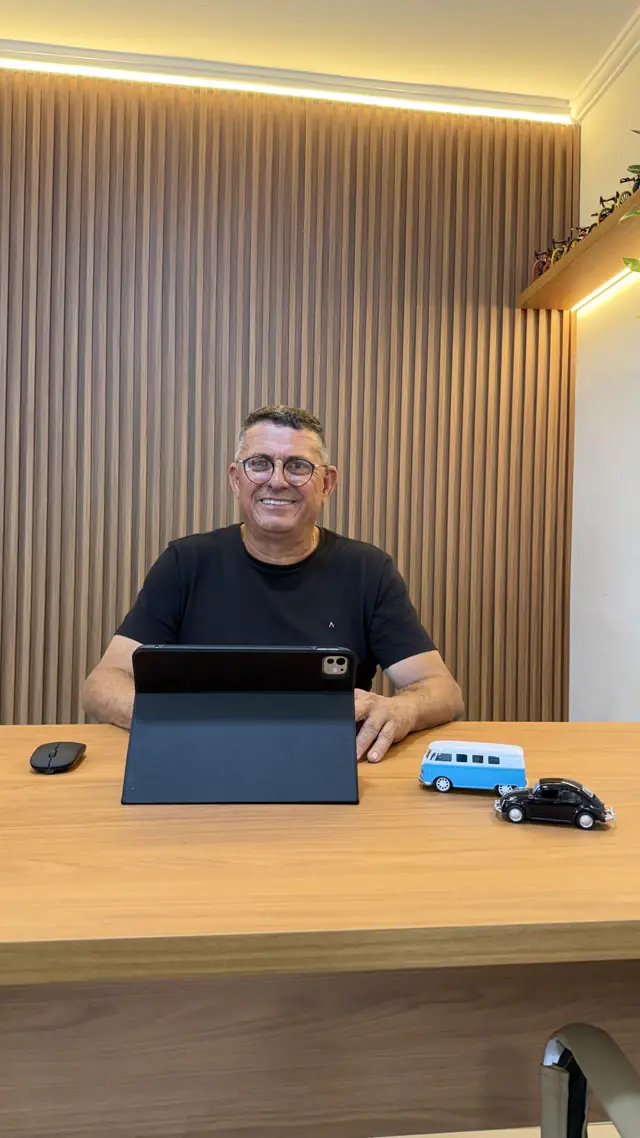 Consultor da Sá Marcos sorrindo à mesa do escritório da loja