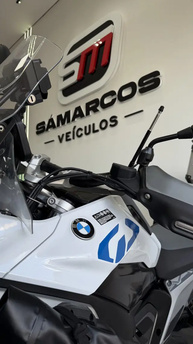 Moto BMW exposta diante do logotipo da Sá Marcos
