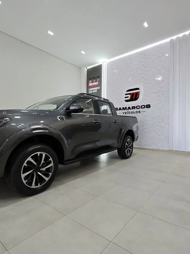 GWM Poer P30 0 km cinza diante da parede com o logotipo da Sá Marcos